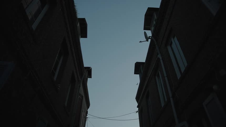 Upward view of residential buildings against a morning sky