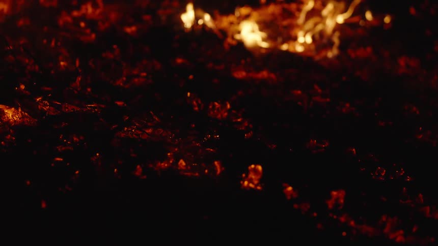 Closeup of a burning ground in slow motion at night