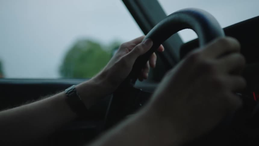 Closeup of the hands of a person driving a vehicle