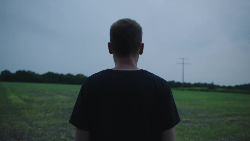 A man is standing on the green field