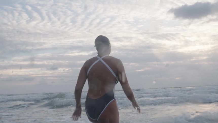 Woman in a swimsuit running towards the sea