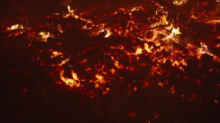 Soil on wood being burned at night in slow motion