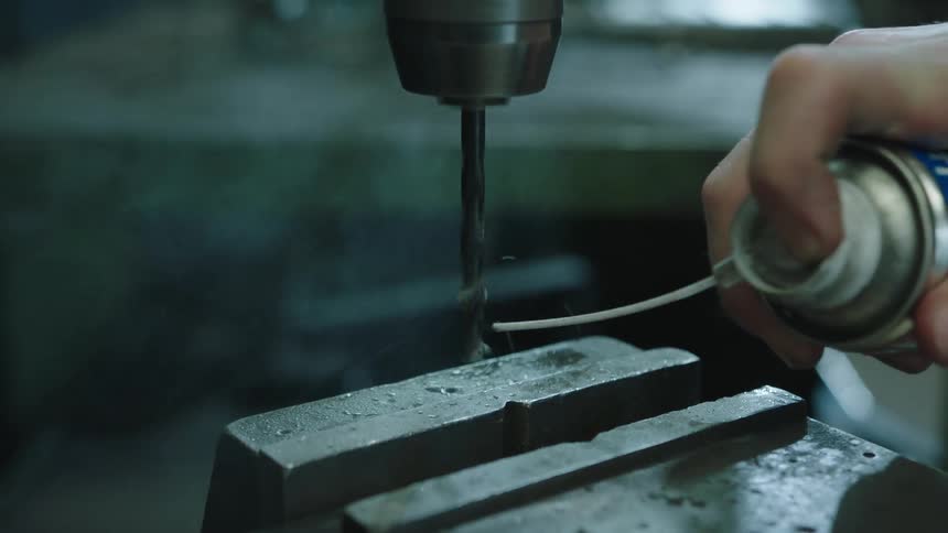 A worker lubricates the drill