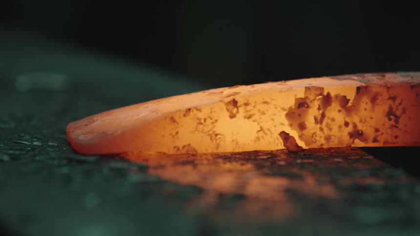 Closeup of metal being shaped with hammer blows