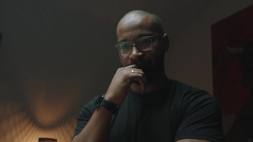 A pondering man brings his hand to his chin