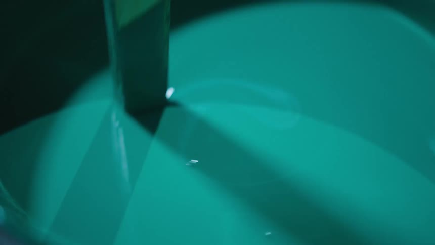 Close up of a stick mixing paing on a bucket