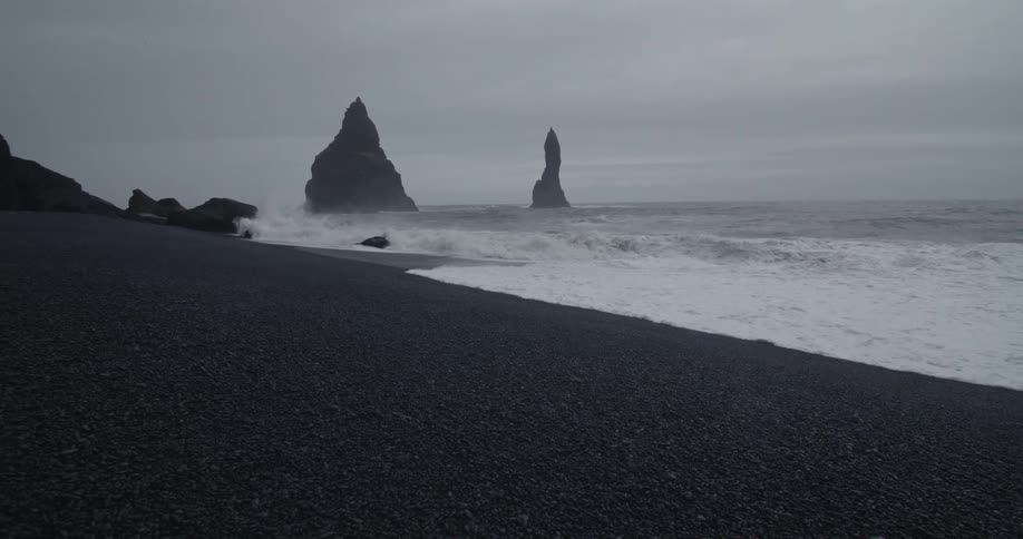 Waves hit the beach hard on a cloudy day