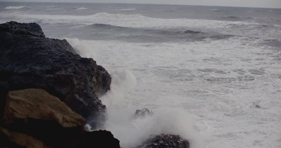 Waves crash against a large rock