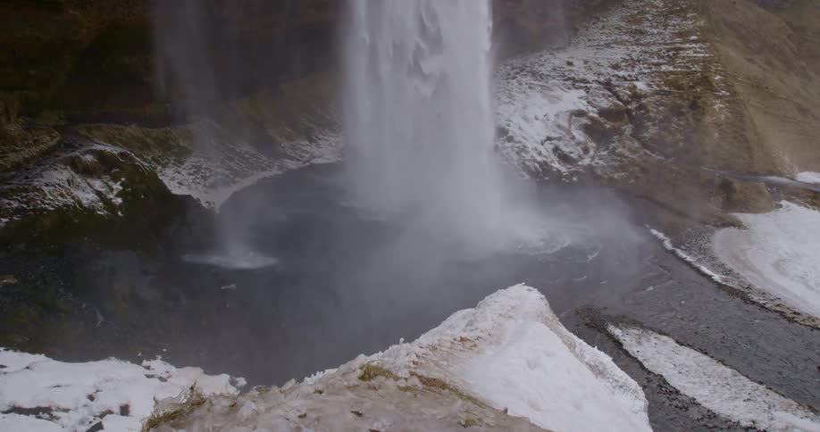 Water falls into a small, rocky pond