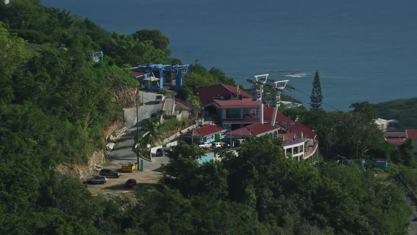 Aerial view of a resort with cable cars in the mountains near the ocean