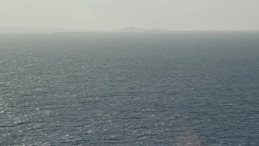 Open ocean land on horizon hazy day