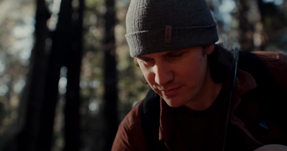 A man looks around in a forest