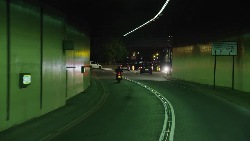 A motorcycle drives through a city tunnel
