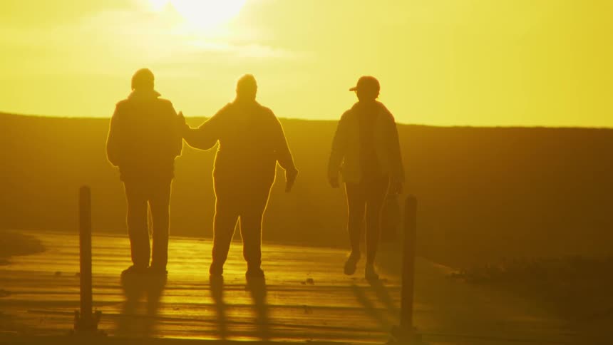 Silhouettes of people walking on a deserted street during the day