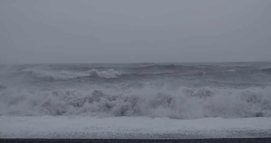 Waves roll onto a beach on a cloudy day