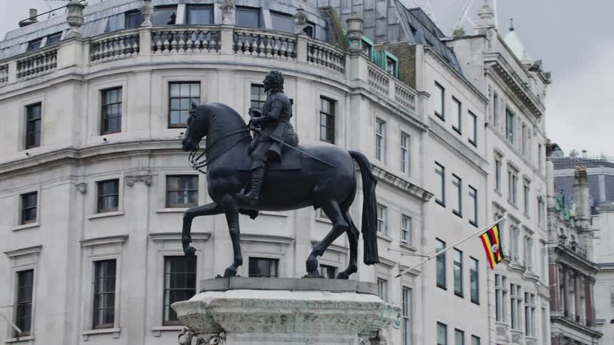 Statue of a man on top of a horse in the center of a metropolis