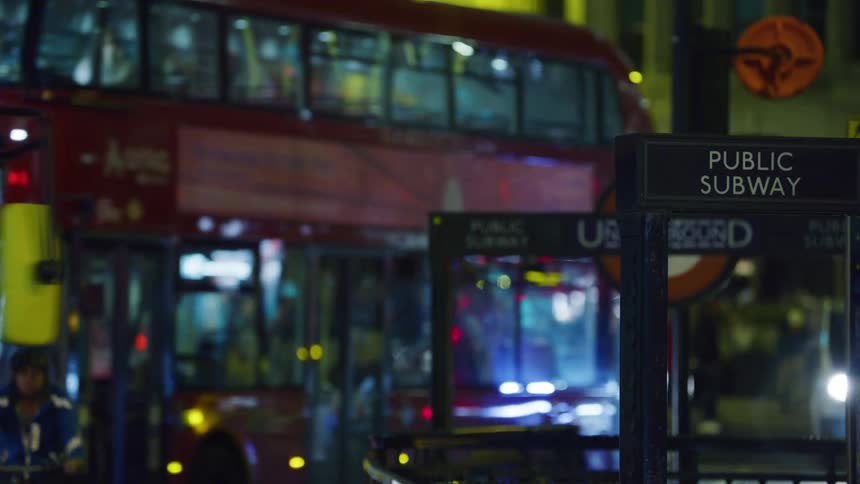 Public street with buses and people passing by at night in the middle of a metropolis