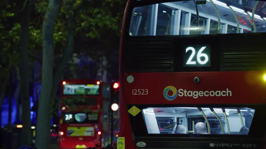A bus parked on the city street at night