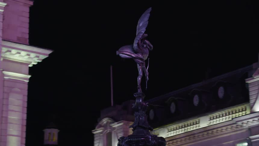 Cupid statue in front of building at night