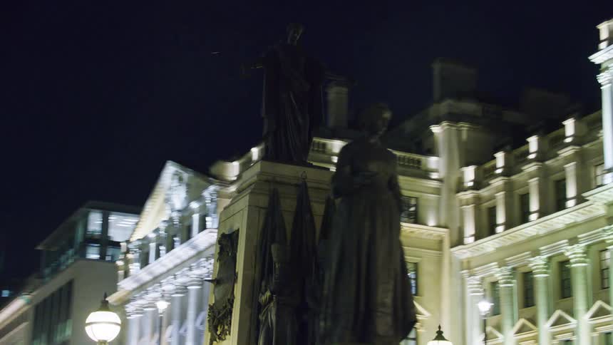 Central bronze statue in the middle of a square at night in the city
