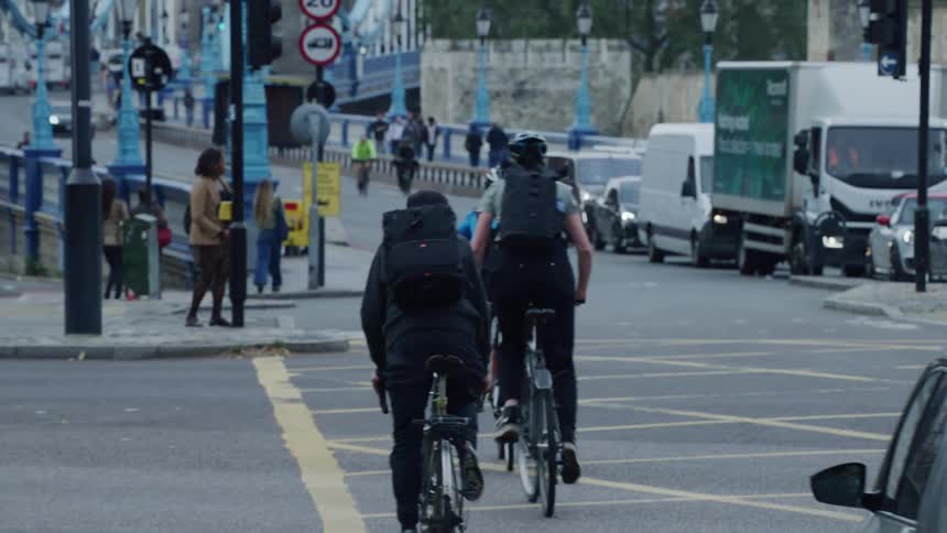 Street leading to a busy bridge with pedestrians cyclists and cars