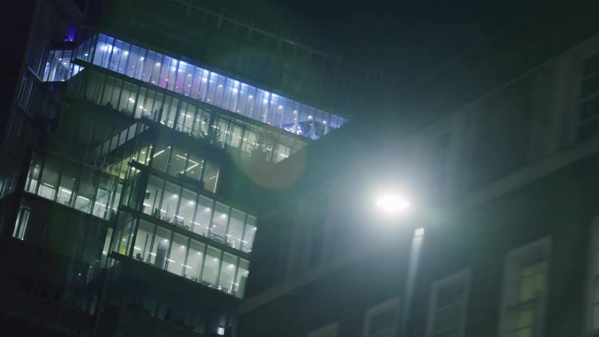 A large office building illuminated at night in the city