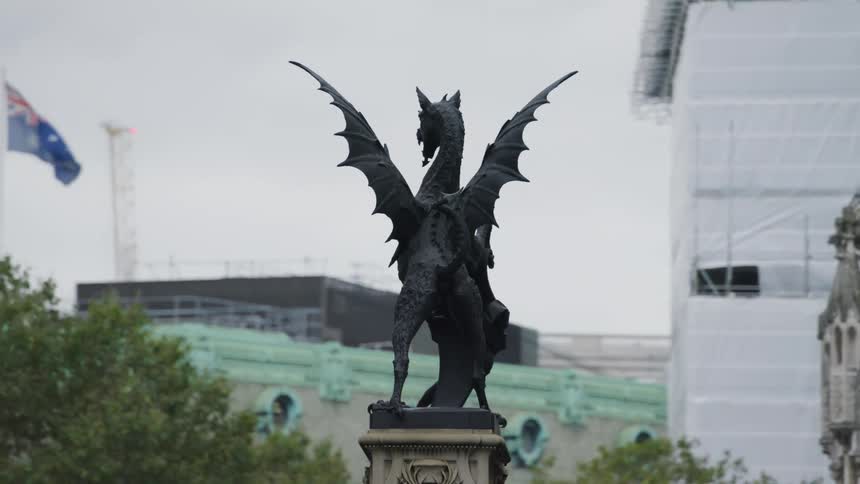 A statue of a dragon in front of a gothic church