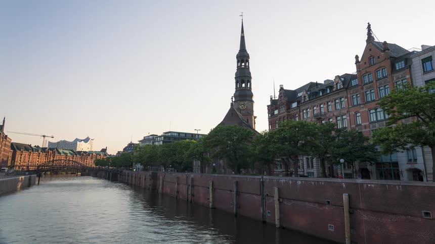 Cars move through a part of a city by a canal