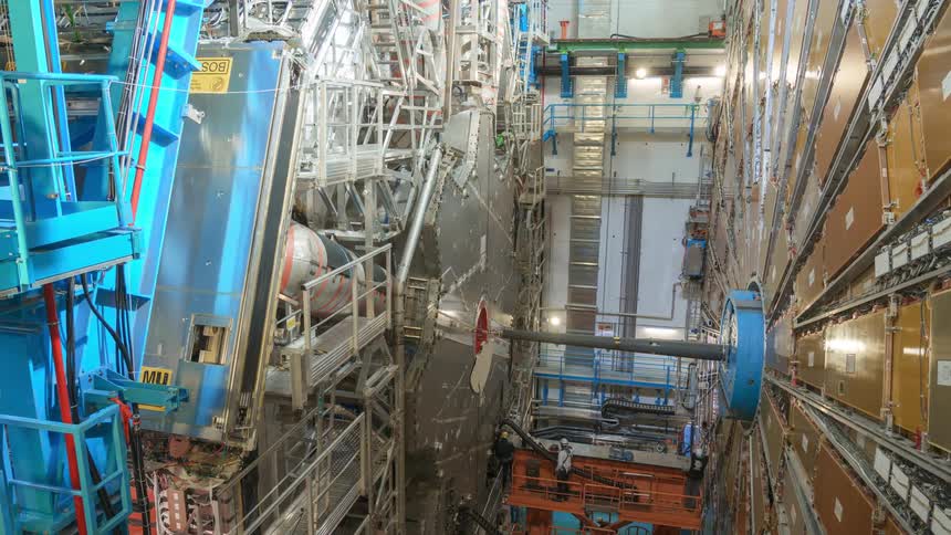 Workers construct large structure with multiple panels attached around large shaft