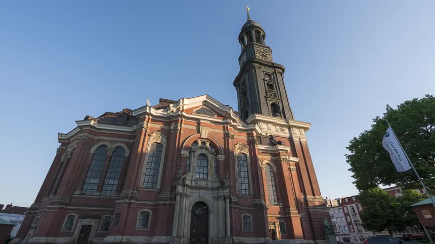 Flags fly in front of an old church