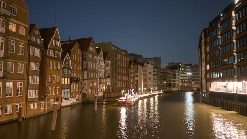 A river runs between two banks with buildings on them