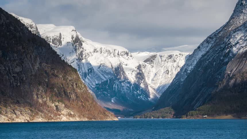 Natural landscape of mountain ranges with vegetation and covered by snow