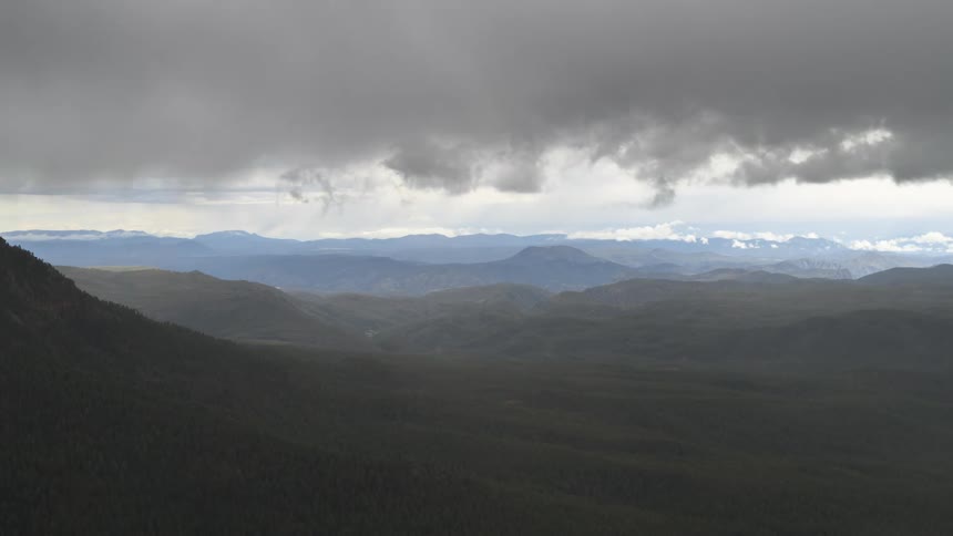 Panoramic view of a mountainous terrain under a dark and sky