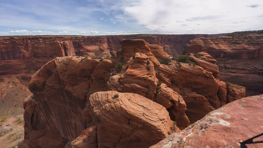 A canyon with intricate rock formations under a cloudy sky