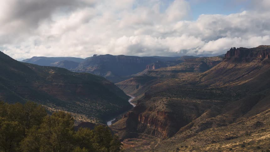 Panorama of canyons and mountains with the central river on a cloudy day in timelapse