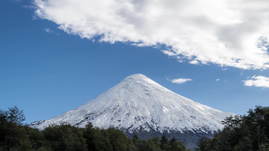 Clouds move over a snow covered mountain