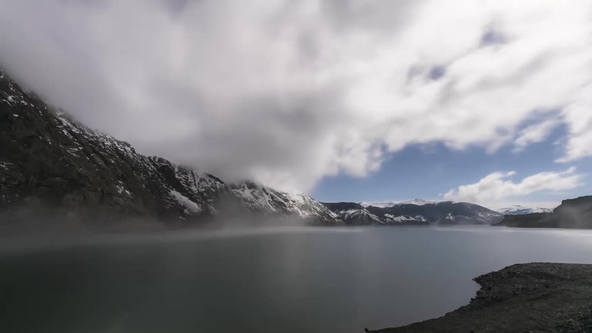 Aerial of a lake surrounded by snowy mountains during winter
