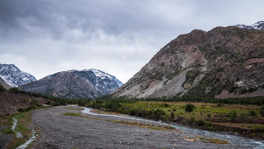 A small river in a plain with rocky mountains