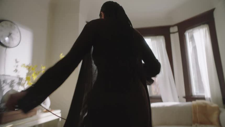 Young happy woman dancing while vacuuming the living room