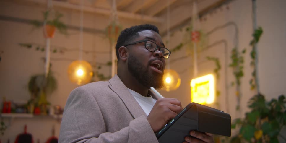 A man writing with a pen on a tablet