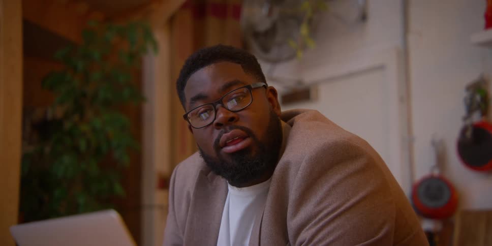 Two black men sitting in a room talking to each other