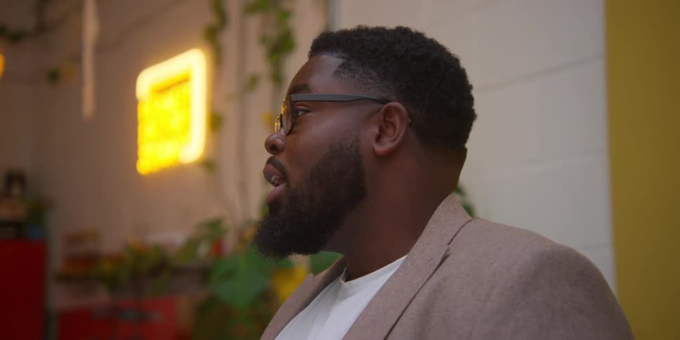 Young bearded man talking lively to someone out of frame