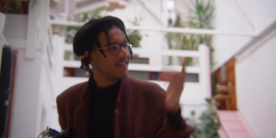 A black man takes a picture while speaking with another man