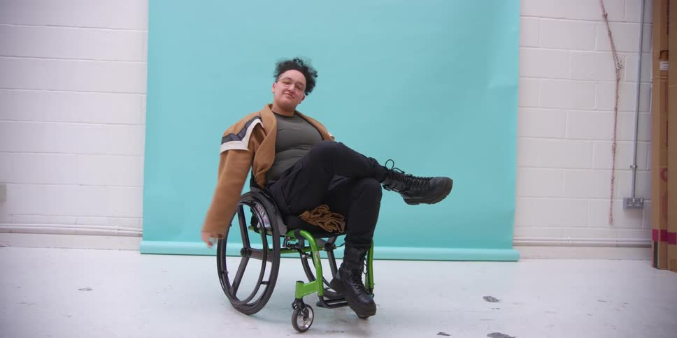 A model in a wheelchair posing for photos in a studio