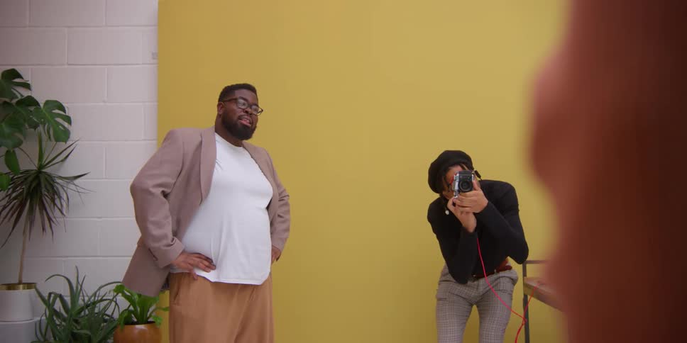 Two black men photograph a model
