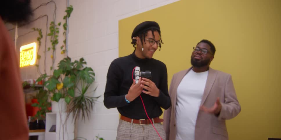 Friends talking to each other inside a studio smiling