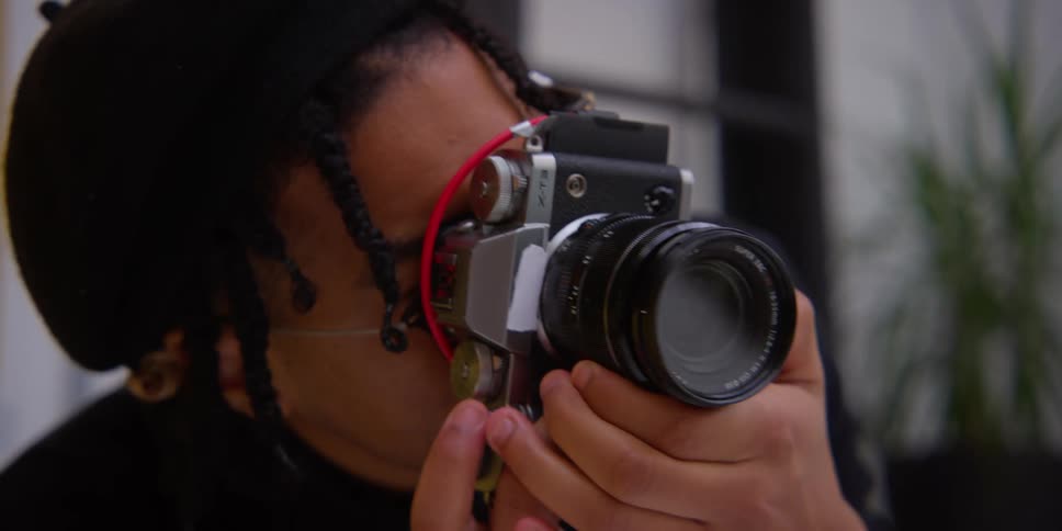 A man holding up a camera in a studio
