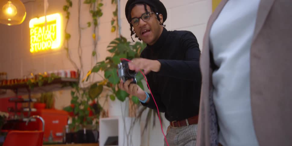 Portrait of a photographer taking photos inside a studio and posing a model