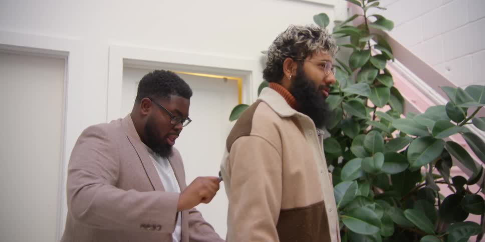 A man is cleaning another mans jacket