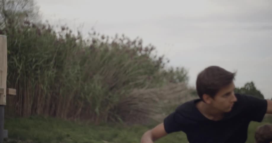 A young boy throws a stone into a lake